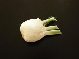 Fennel bulb in a wicker bowl on a black table background photo