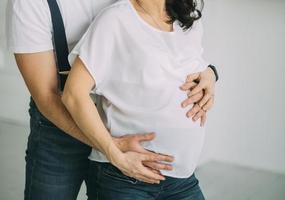Pregnant couple holding belly photo