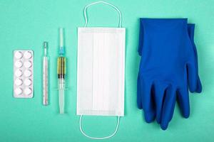 Medical products for protection against coronavirus pandemic covid-19 on blue green background photo
