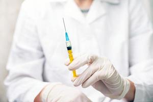 Doctor holds a syringe with medicine