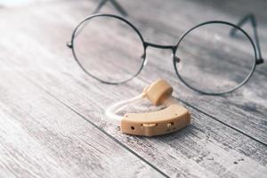 Hearing aid equipment on wooden background photo