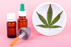 Cannabis-based cosmetic oils and bottles with marijuana extract photo