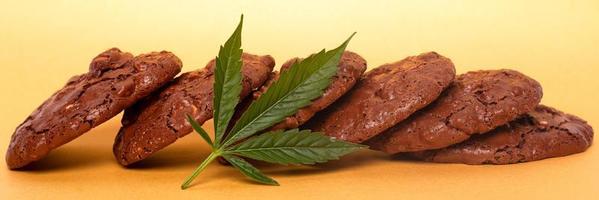 Cannabis cookies and green leaf on a yellow background photo