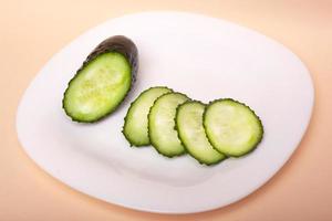 Sliced fresh cucumbers on a white plate photo