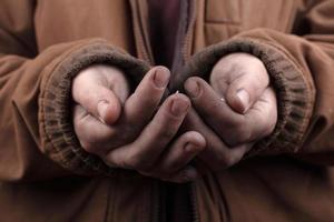 Beggar concept, outstretched hands of a homeless person asking for help photo