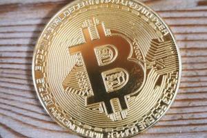 Close up of a Bitcoin cryptocurrency coin on a wooden background photo