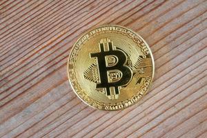 Bitcoin on a wooden surface background. Bitcoin cryptocurrency. Golden metal bitcoin crypto currency concept photo