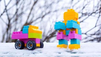 invierno año nuevo coche de juguete y robot en la nieve en la calle foto