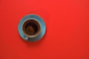 Coffee cup isolated on red background with copy space. Top view of strong morning coffee. photo