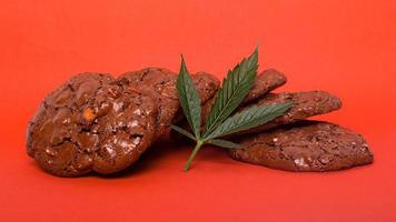 Sweets with marijuana on red background. photo