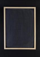 Empty clean black drawing chalkboard with wooden frame on black background. photo