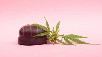 Chocolate marshmallows with THC content on pink background photo