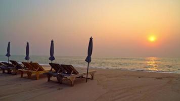 chaises de plage sur la plage au coucher du soleil video
