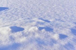 Snowy surface in winter with shadows in the evening photo