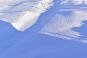 Snowy surface in winter with shadows in the evening photo