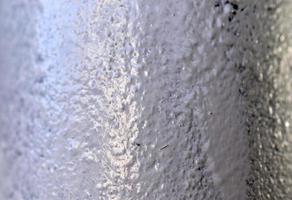 The surface of a white painted iron pipe close-up photo