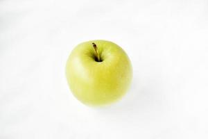 una manzana verde brillante sobre un fondo blanco foto