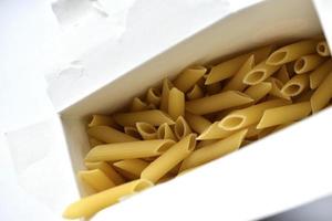 Yellow macaroni from a paper box on a white background photo