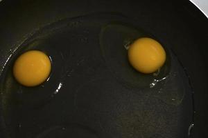 Two chicken eggs in a frying pan for frying food photo