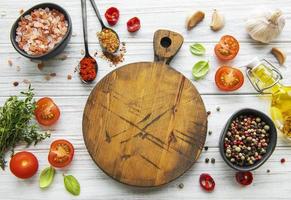 Cooking wooden utensils, empty cutting board and spices. Food cooking template concept. Top view with copy space. Flat lay photo