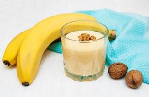 Banana smoothie with chocolate on an old white wooden background photo