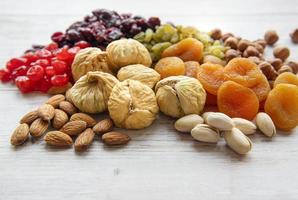 Various dried fruits and nuts on a wooden background photo