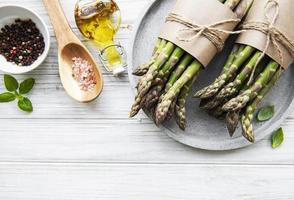 Bunch of raw asparagus stems with different spices photo