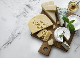 Various types of cheese, grapes, and honey photo