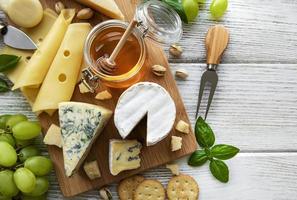 Various types of cheese on a white wooden background photo