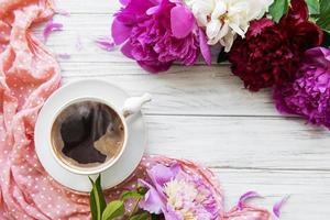 flores de peonía rosa y una taza de café foto