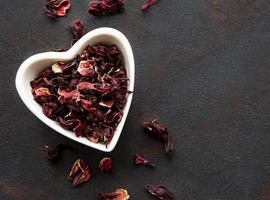 Hibiscus tea in white bowl. Slate background. Copy space. photo