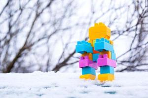 Toy robot in the snow, homemade little winter robot photo