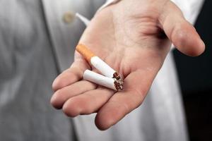 Broken cigarette in the hand of a doctor close-up photo