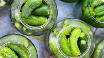 Pickled cucumbers in glass jars close-up photo