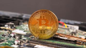 Moneda de oro bitcoin cryptocurrency a bordo de la computadora foto