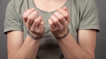 Person under arrest, woman handcuffed for financial fraud, concept of law photo