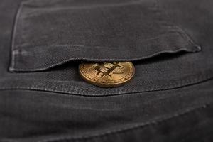 Metal bitcoin coin in pants pocket photo