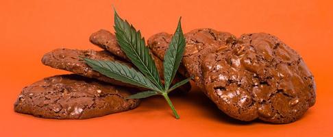 Sweets with marijuana on red background photo