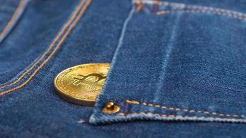 Bitcoin coin in jeans pocket photo