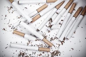 Broken cigarettes on white background, close-up