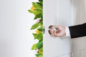 hombre de negocios, abrir la puerta, con, hojas, y, flores foto