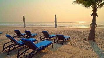 Sonnenschirm und Liegestühle am Strand bei Sonnenuntergang video