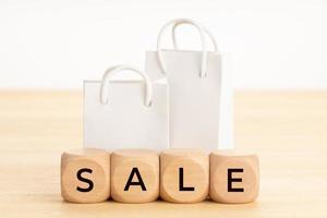 Sale word on wooden blocks and paper shopping bag photo