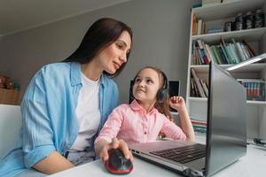 Mom assisting daughter with virtual learning photo