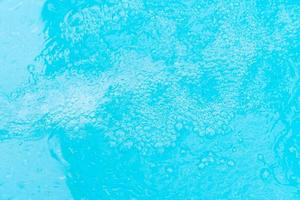 Bubbling water background of a blue swimming pool photo