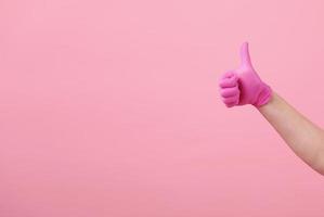 Hands of a girl in pink latex gloves on pink background. Virus protection, medical sterility photo