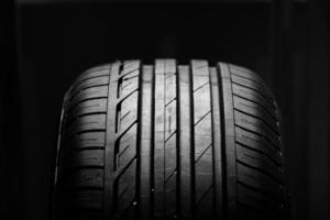 Studio shot of brand new car tire isolated on black background. Close up photo