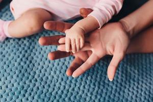 Mom and Dad hold baby's hand. Children's handle photo