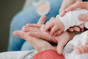 Mom and Dad hold baby's hand. Children's handle photo