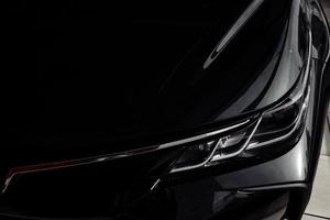 Headlight of modern prestigious black car close up